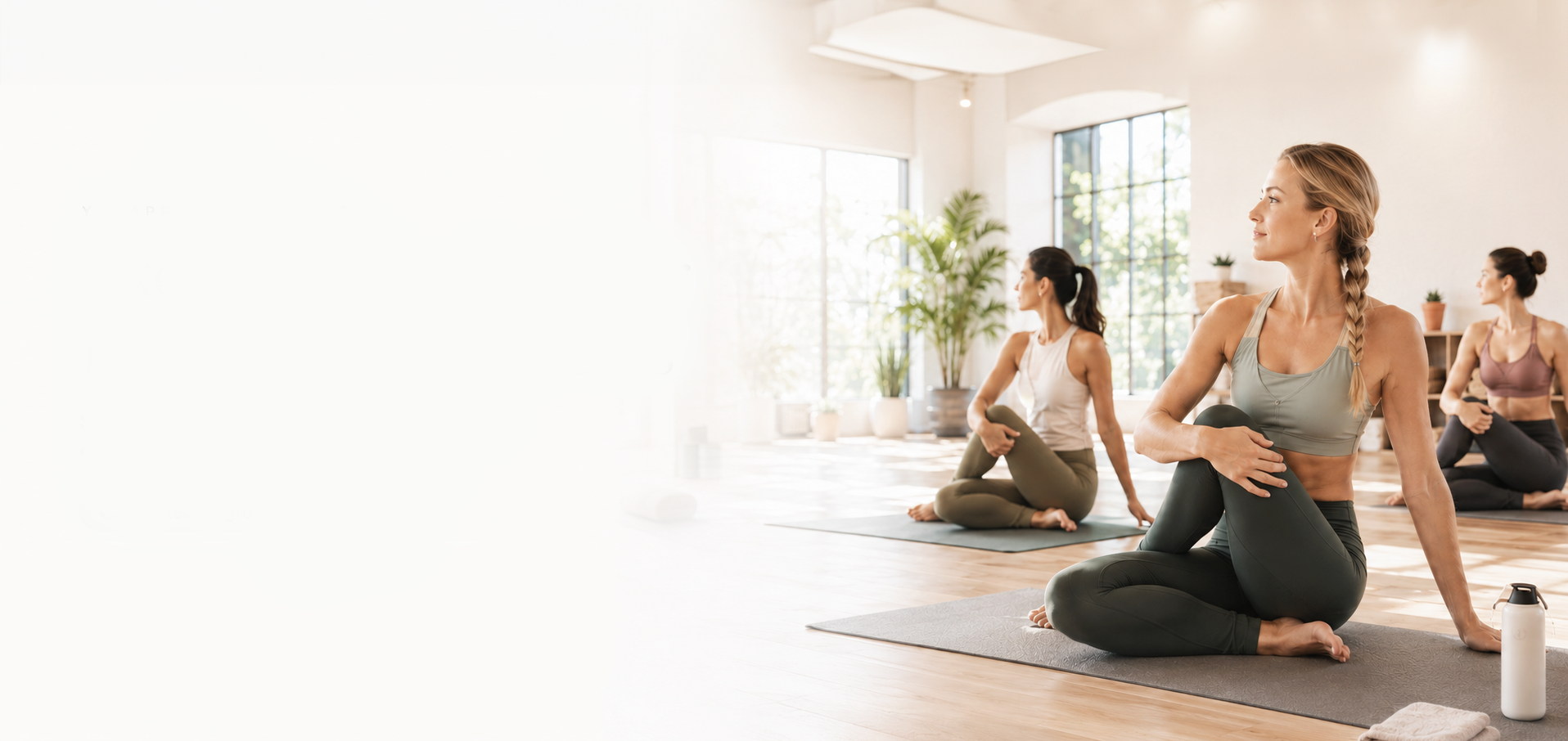 Yoga class practising seated twists in a bright, sunlit studio
